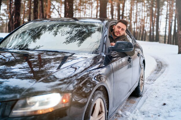 young man in car winter road