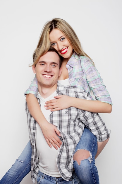 Young man carrying girlfriend on his back.