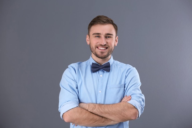 Young man in casual clothes on grey background