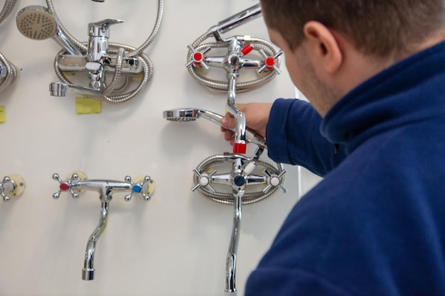 Young man choosing bath mixer