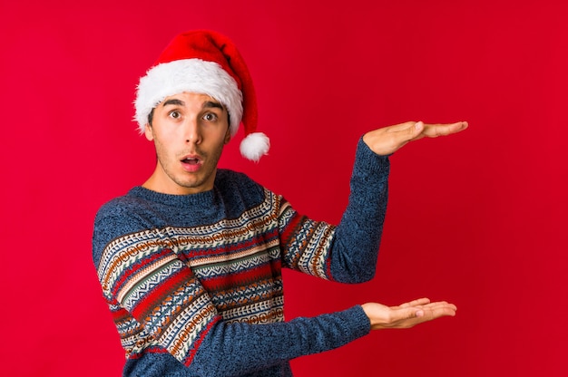 Young man on christmas day holding a copy space on a palm.