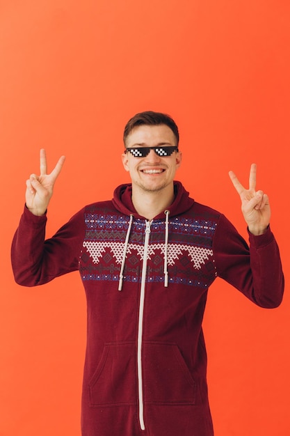 A young man in a Christmas kigurumi and sunglasses on a colored background