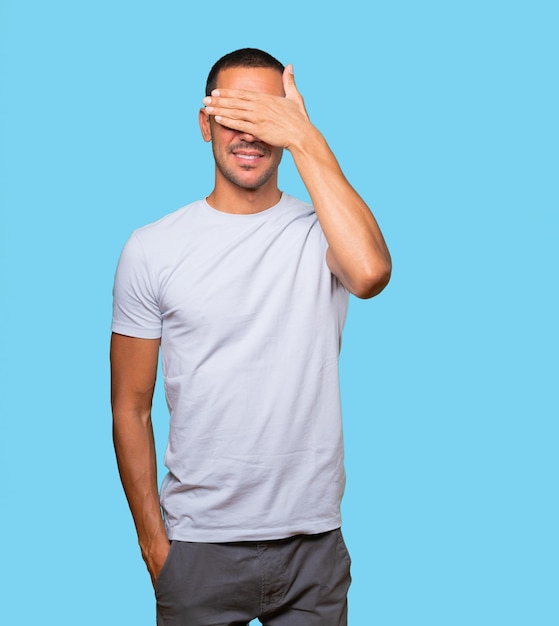 Young man covering his eyes with his hands