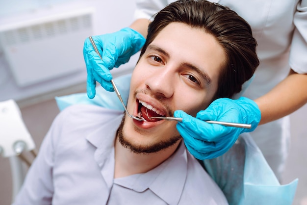 Young man at the dentist's chair during a dental procedure Overview of dental caries prevention