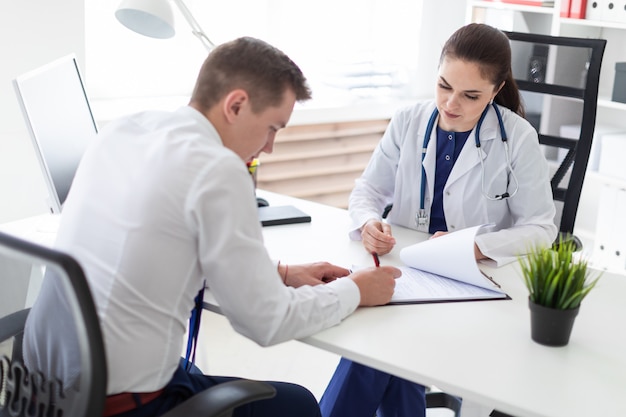 The young man at the doctor's office signs the documents