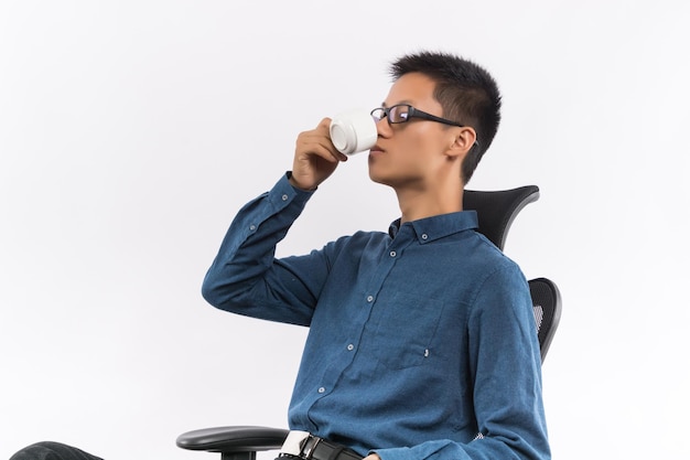 Young man drinking asian natural tea porcelain cup