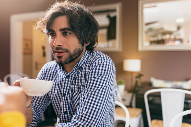 Young man drinking a tea at cafe with his girlfriend.