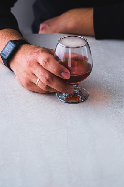 A young man drinks cognac in a restaurant at a meeting.