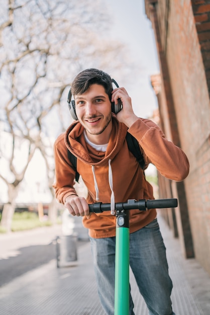 Young man driving electric scooter.