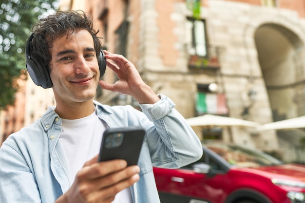 Young man enjoys the convenience of mobile music wearing headphones