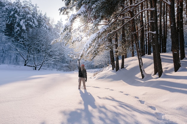 Young man enjoys the winter season in a snow-covered pine forest