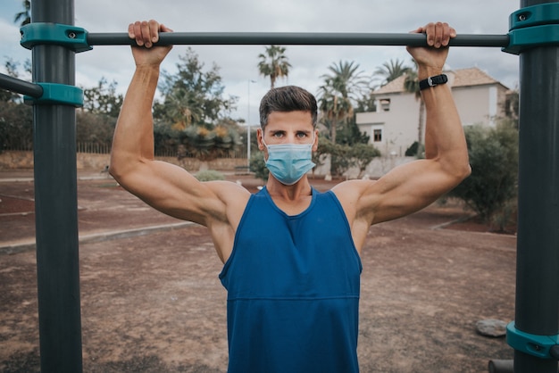 Young man exercises with face mask outdoors