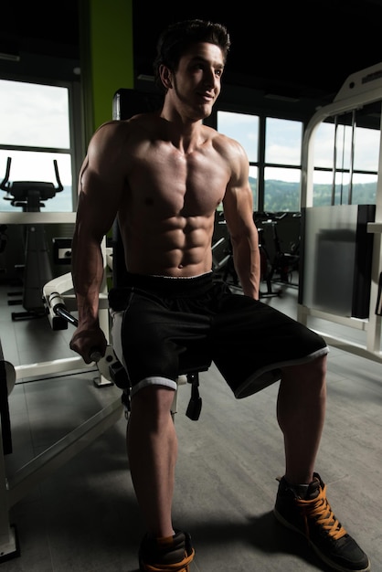 Young Man Exercising Triceps In The Gym