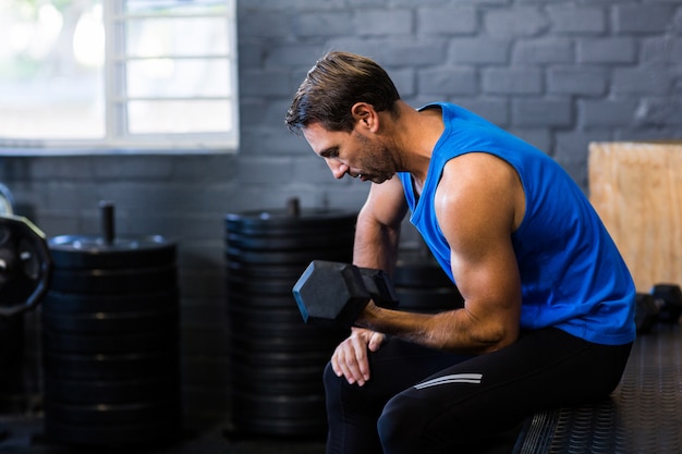 Young man exercising with dumbbell