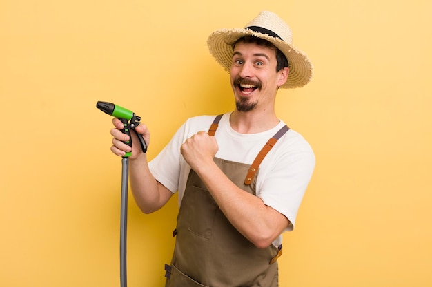 Young man farmer with a hose gardering concept