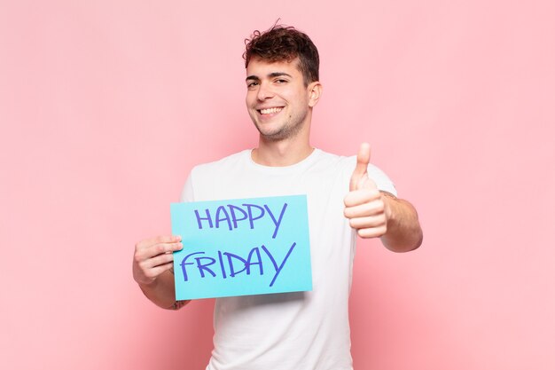 Photo young man feeling proud, carefree, confident and happy, smiling positively with thumbs up