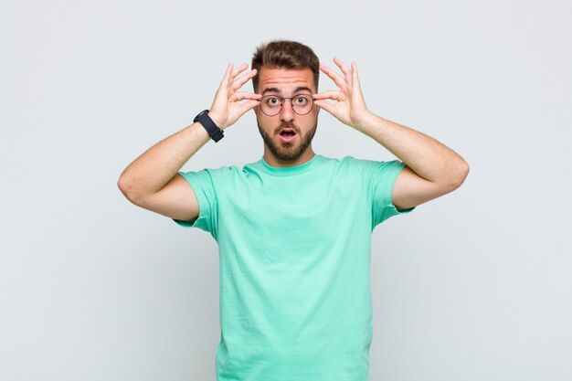 Young man feeling shocked, amazed and surprised