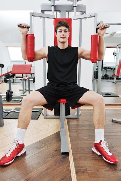 young man in fintess sport club exercise withweights and relaxing