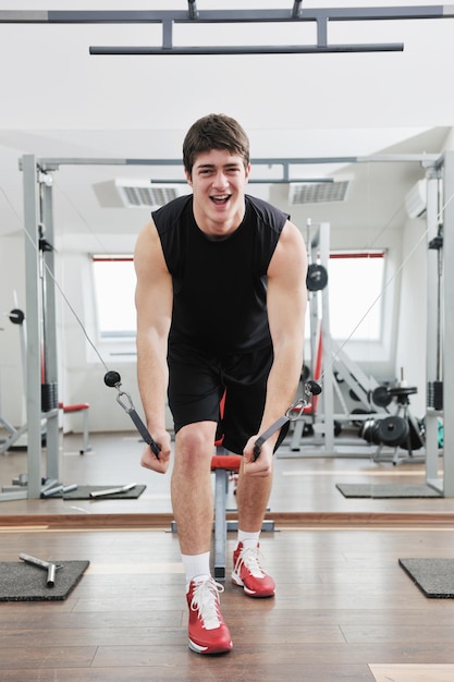 young man in fintess sport club exercise withweights and relaxing