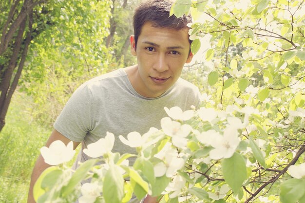 The young man next to a flowering quince bush