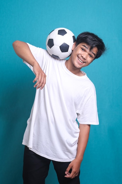 Young man football soccer player balancing soccer ball on the neck, street baller football trick