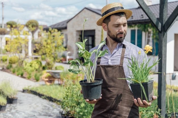 Young man gardener with perennial plants in hands