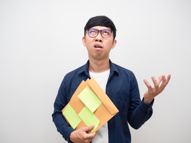 Young man glasses holding document papers feel tried looking up isolatedMan feel mad with work