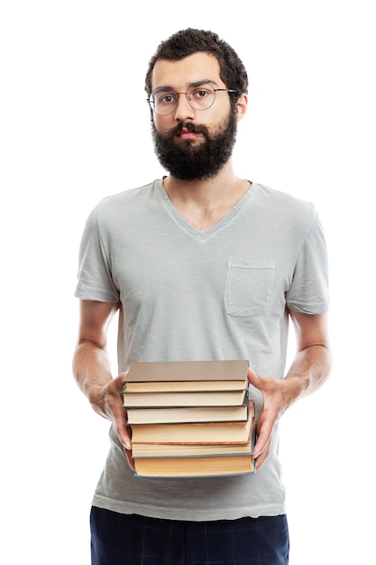 young man in glasses and with a beard with books in his hand. Education and training.