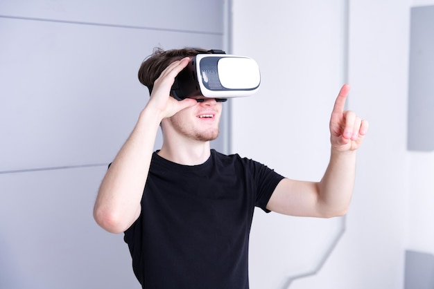 Young man guy wearing modern device virtual reality VR mask headset or glasses 3D AR metaverse