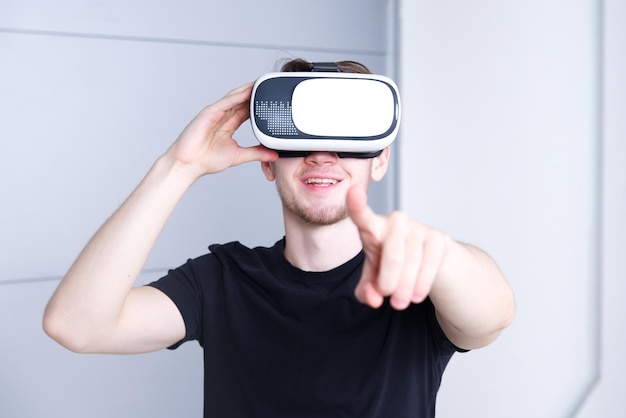 Young man guy wearing modern device virtual reality VR mask headset or glasses 3D AR metaverse