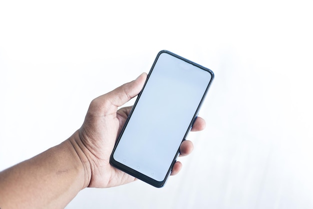 Young man hand using smart phone against white wall