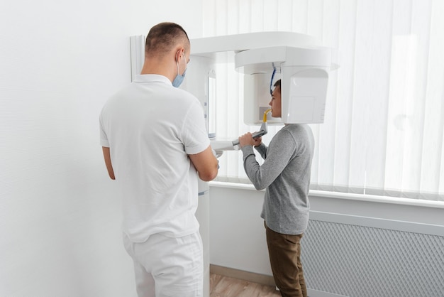 A young man has a computed tomography of the jaw a circular snapshot of the jaw in modern dentistry Prevention of caries prosthetics and dental treatment Radiology panoramic scanner