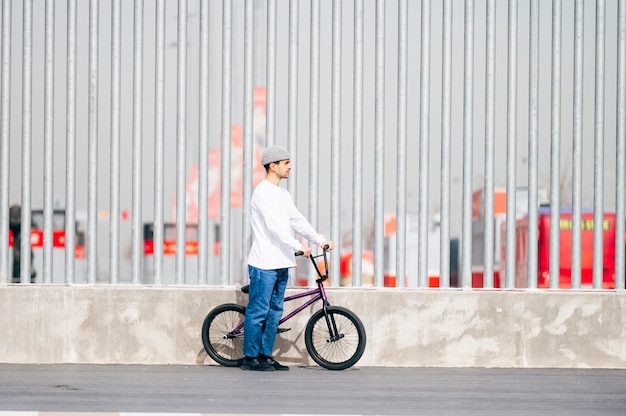 Young man next to his bicycle posing 