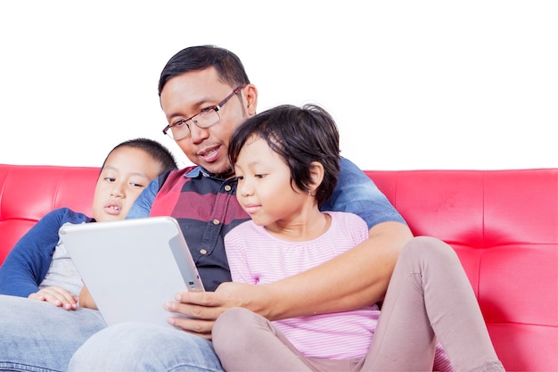 Young man and his children using tablet on studio