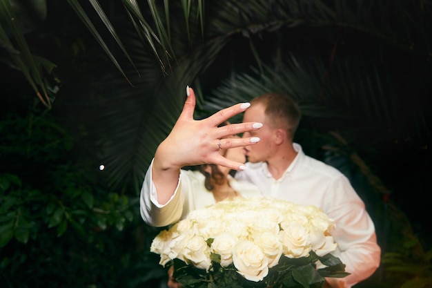 Young man and his happy fiancee showing engagement ring