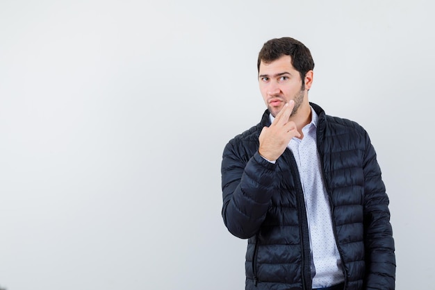 Young man holding a hand gun on white background