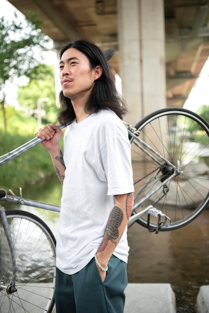 Young man holding his bike