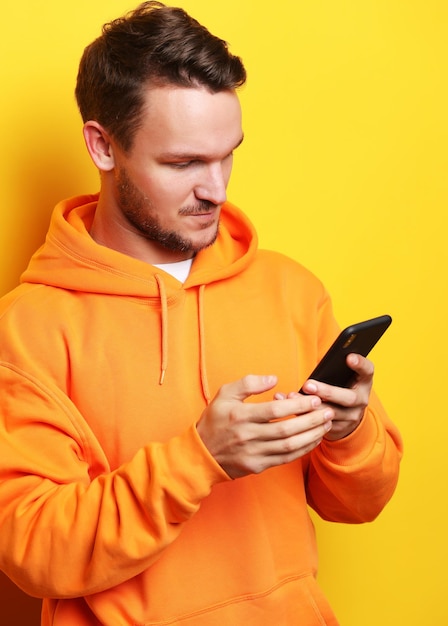 Young man holding mobile phone and making photo