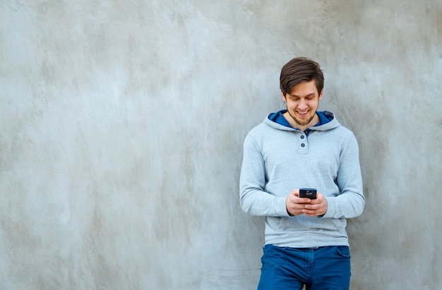 Young man holding a phone in hands