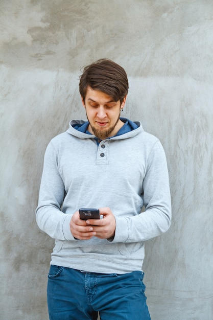 Young man holding a phone in hands