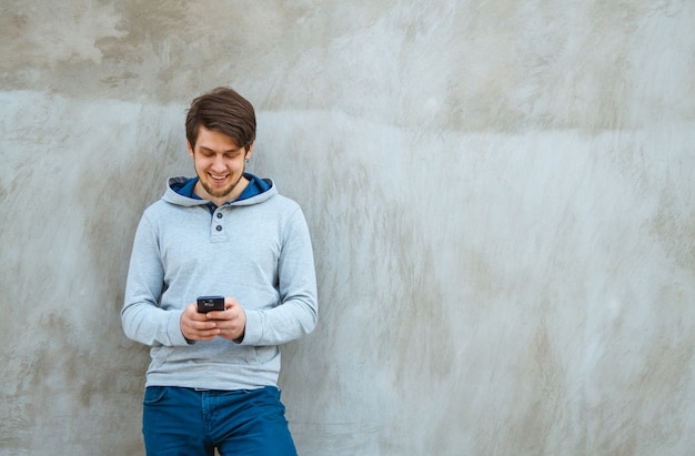 Young man holding a phone in hands