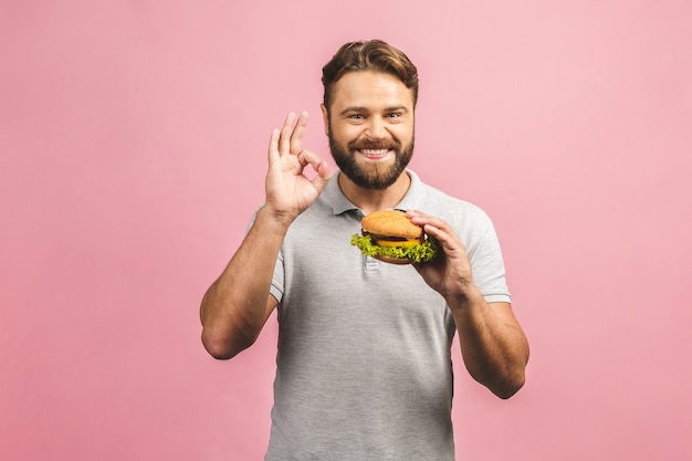 Young man holding a piece of hamburger