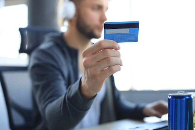 Young man holding and using credit card for game money top up, close up credit card.