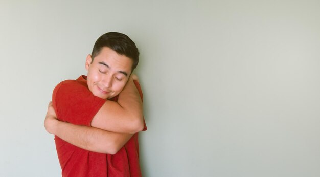 Young man hugging himself in love smiling staying single