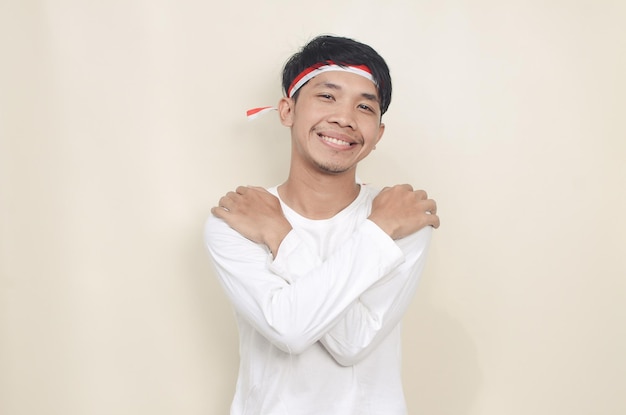 Young man hugging himself wearing a ribbon on his head