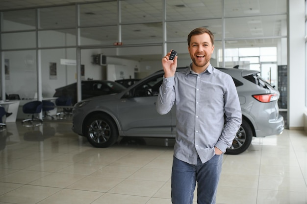 Young man is choosing a new vehicle in car dealership