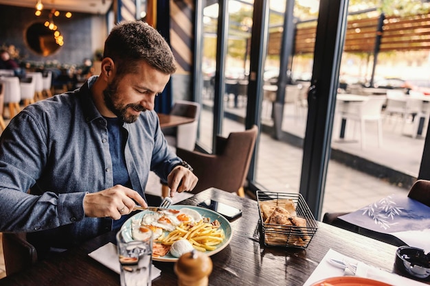 A young man is having eggs for breakfast at the restaurant