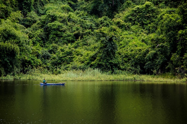 Young man is rowing in the middle of the valley.