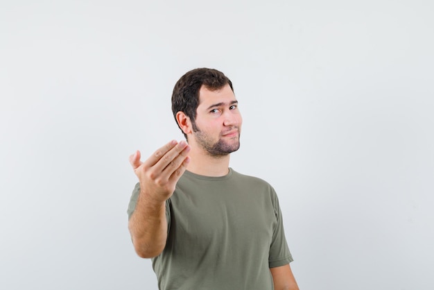 The young man is showing come gesture with hand on white background