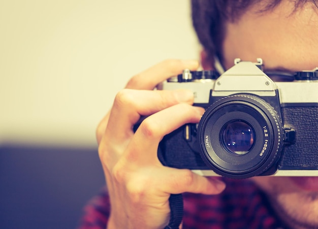 Young man is taking a picture with a vintage camera